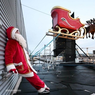 Auf den Dächern der Sparkasse Bochum: Portraitfotografie vom fliegenden Weihnachtsmann Falko Traber, kurz bevor er über dem Bochumer Weihnachtsmarkt schwebt