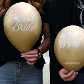 Nahaufnahme von goldenen Luftballons mit Aufschrift "Team Bride"