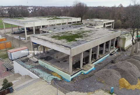 Das Foto zeigt das Schulgebäude während der Bauphase: Im Vordergrund das entkernte Schwimmbad, dahinter die Umkleiden und ganz dahinter oben links die entkernte Sporthalle